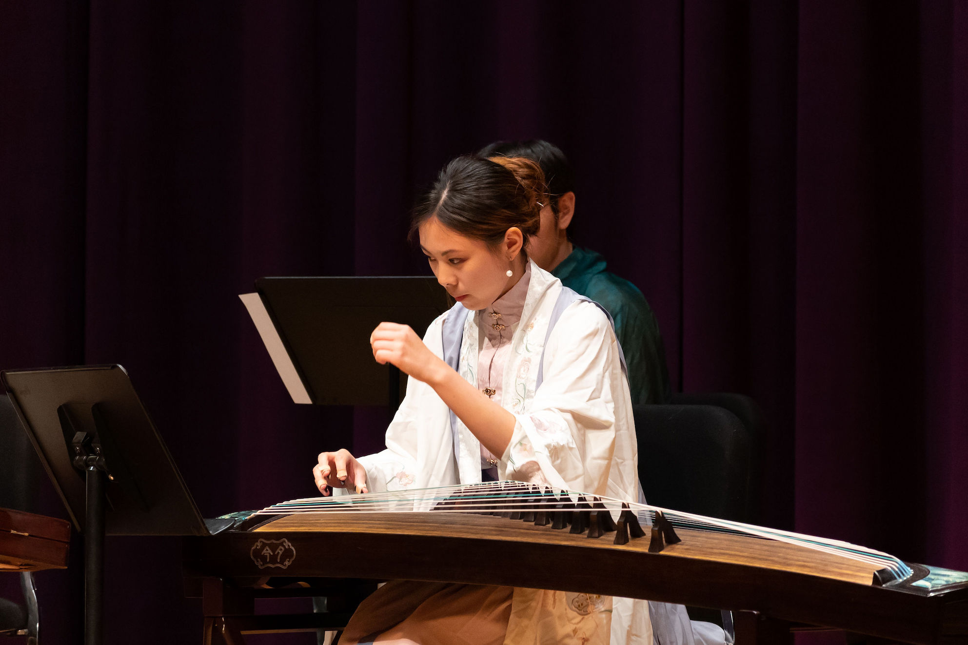 Photo of an instrumentalist playing the guzheng